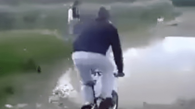 VIDEO Intento cruzar charco en bicicleta y se hace viral