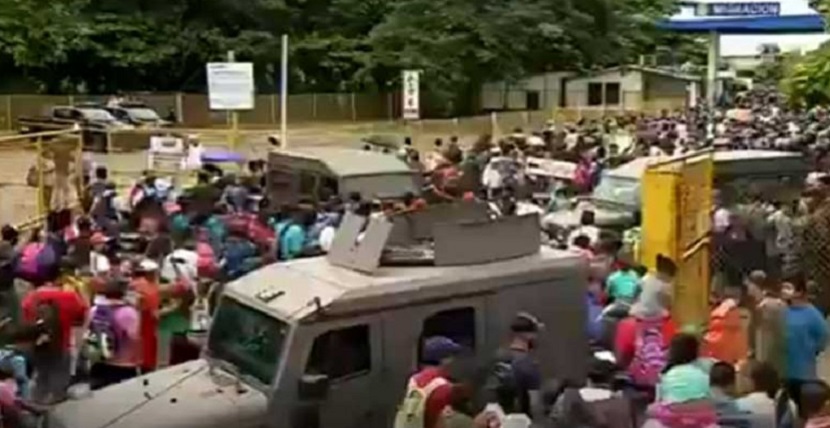 Caravana de hondureños derriba valla e ingresa a México